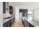 Stylish kitchen featuring dark cabinetry, granite countertops, and stainless steel appliances at 31672 N 135Th Ln, Peoria, AZ 85383