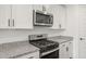 Close up on the kitchen with stainless steel microwave, stove and granite countertops at 32076 N 136Th Ave, Peoria, AZ 85383
