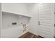 A white laundry room features built-in shelving, hookups, and a paneled white door at 32076 N 136Th Ave, Peoria, AZ 85383