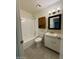 Tile bathroom with wood cabinet, shower/tub combo, and stylish lighting at 3613 W El Caminito Dr, Phoenix, AZ 85051