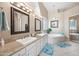 Bathroom with dual sinks, granite countertop, vanity mirror, soaking tub and glass block window at 4503 E Robin Ln, Phoenix, AZ 85050