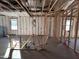 Exposed beams, studs, and insulation showcase the unfinished interior with multiple windows and bare concrete floor at 47747 W Kenner Dr, Maricopa, AZ 85139