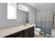 Stylish bathroom featuring a patterned shower curtain, dark vanity, and neutral color palette at 62 W Secretariat Dr, Tempe, AZ 85284