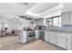 Well-lit kitchen with stainless steel appliances, tile flooring, and gray painted cabinetry at 62 W Secretariat Dr, Tempe, AZ 85284
