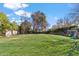 Expansive backyard featuring a large grassy area, mature trees, and playground equipment for outdoor enjoyment at 620 W Mclellan Blvd, Phoenix, AZ 85013