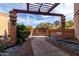 An inviting outdoor entry with pergola, stone pathway, and lush garden leads to a gated courtyard at 6336 N 48Th Pl, Paradise Valley, AZ 85253