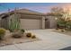 Exterior view of the home's garage, with a desert landscaped front yard and a paved driveway at 7111 E Sienna Bouquet Pl, Scottsdale, AZ 85266