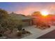 A desert home at sunset, showing the well-manicured landscape and spacious driveway at 7111 E Sienna Bouquet Pl, Scottsdale, AZ 85266