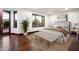 Bright bedroom featuring a large bed, bench seating, hardwood floors and ample natural light at 7111 E Sienna Bouquet Pl, Scottsdale, AZ 85266