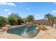 A beautiful backyard pool with a waterfall feature, fire pit, and desert landscaping at 7111 E Sienna Bouquet Pl, Scottsdale, AZ 85266