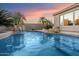 Beautiful pool area with a waterfall feature and fire pit under a colorful dusk sky at 7111 E Sienna Bouquet Pl, Scottsdale, AZ 85266