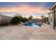 Outdoor pool area with a waterfall and desert landscaping with an adjacent stone patio at 7111 E Sienna Bouquet Pl, Scottsdale, AZ 85266
