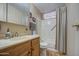 Bathroom featuring wood cabinets, updated sink, and a shower/bath combo with all white at 7408 E Bosaga Way, Mesa, AZ 85208