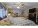 Comfortable bedroom with a ceiling fan, a bed with patterned bedding, and lamps at 7408 E Bosaga Way, Mesa, AZ 85208