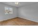 This bedroom boasts warm wood floors, a ceiling fan, and a window for natural light at 8064 E Madero Ave, Mesa, AZ 85209