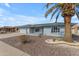 Single-story home features low-maintenance desert landscaping and a stately palm tree at 8064 E Madero Ave, Mesa, AZ 85209
