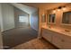 Bathroom featuring a double sink vanity and a view of the bedroom at 8154 W Greer Ave, Peoria, AZ 85345