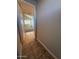 Hallway with tile flooring leading to a carpeted bedroom with window views at 8154 W Greer Ave, Peoria, AZ 85345