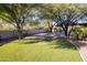 Lush backyard featuring a putting green, mature trees and desert landscaping at 8155 E Juan Tabo Rd, Scottsdale, AZ 85255
