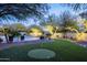 Beautiful backyard with a pool, putting green, desert landscaping, and festive tree lighting at 8155 E Juan Tabo Rd, Scottsdale, AZ 85255