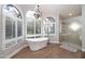Bathroom featuring stained-glass windows, a freestanding tub, and tiled shower at 8155 E Juan Tabo Rd, Scottsdale, AZ 85255