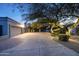 Long driveway with a three-car garage, desert landscaping, and festive tree lighting at 8155 E Juan Tabo Rd, Scottsdale, AZ 85255