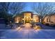 Charming home exterior with a stone entrance, lush desert landscaping, and pathway lighting at 8155 E Juan Tabo Rd, Scottsdale, AZ 85255