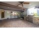 Outdoor patio featuring stone accents, ceiling fan and a stainless steel grill and counter space at 8155 E Juan Tabo Rd, Scottsdale, AZ 85255