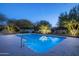 Sparkling pool with desert landscaping and trees lit with festive lights at 8155 E Juan Tabo Rd, Scottsdale, AZ 85255