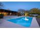 Backyard pool with a covered patio, desert landscaping, and tree lighting at 8155 E Juan Tabo Rd, Scottsdale, AZ 85255