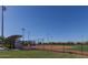 Well-maintained baseball field with covered bleachers, grassy outfield, and clear blue skies at 8486 W Mantle Way, Florence, AZ 85132