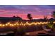 A backyard with a fire pit, string lights, desert landscaping, and a sunset at 8662 W Paradise Ln, Peoria, AZ 85382
