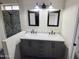 Bright bathroom boasts double vanity with marble countertop, stylish mirrors, and modern lighting fixtures at 8662 W Paradise Ln, Peoria, AZ 85382