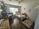 Bright bedroom featuring wood floors, a ceiling fan and a comfortable bed and a desk at 8662 W Paradise Ln, Peoria, AZ 85382