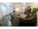 Open-concept living room featuring dark wood floors, a large leather sofa, and access to the dining area at 8662 W Paradise Ln, Peoria, AZ 85382
