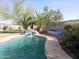 A pool with a waterfall feature, desert landscaping, and privacy walls at 8662 W Paradise Ln, Peoria, AZ 85382