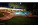 Inviting backyard pool with lush landscaping and decorative lighting, perfect for evening relaxation at 8662 W Paradise Ln, Peoria, AZ 85382