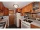 Cozy kitchen features vintage wood cabinetry, updated white appliances, and dark wood floors at 8819 N 12Th Pl, Phoenix, AZ 85020