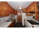 Compact kitchen featuring wood cabinets, marbled countertops, stainless steel sink, and modern appliances at 8819 N 12Th Pl, Phoenix, AZ 85020