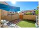 Private backyard featuring artificial turf, a blue umbrella, and a wooden fence, perfect for outdoor relaxation at 921 W University Dr # 1143, Mesa, AZ 85201