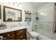 Well-lit bathroom featuring wood vanity, marble backsplash, toilet, and shower-tub combination at 921 W University Dr # 1143, Mesa, AZ 85201