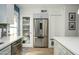 Modern kitchen featuring stainless steel appliances, white cabinets, and a stylish pantry door at 921 W University Dr # 1143, Mesa, AZ 85201