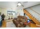 Spacious living area with wood floors, a fireplace, a ceiling fan, and a staircase leading to the second floor at 921 W University Dr # 1143, Mesa, AZ 85201