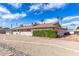 Home's backyard with gravel landscaping, mature bushes, and solar panels at 10801 W Mountain View Rd, Sun City, AZ 85351