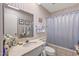 Bright bathroom featuring a shower-tub combo, white marble countertop, and striped wallpaper at 10801 W Mountain View Rd, Sun City, AZ 85351