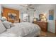 Warm bedroom showcasing a ceiling fan, white bedding, and a vanity area at 10801 W Mountain View Rd, Sun City, AZ 85351