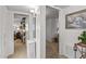 Hallway with white walls, leading to other rooms, enhanced with a decorative painting at 10801 W Mountain View Rd, Sun City, AZ 85351