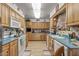 Bright kitchen with white appliances, light wood cabinetry, and a layout designed for efficient cooking at 10801 W Mountain View Rd, Sun City, AZ 85351