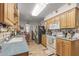 Efficiently designed kitchen features essential appliances, wood cabinetry, and ample counter space for meal preparation at 10801 W Mountain View Rd, Sun City, AZ 85351