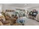 Bright living room with comfortable seating, a large glass door to the patio, and a modern ceiling fan at 10801 W Mountain View Rd, Sun City, AZ 85351